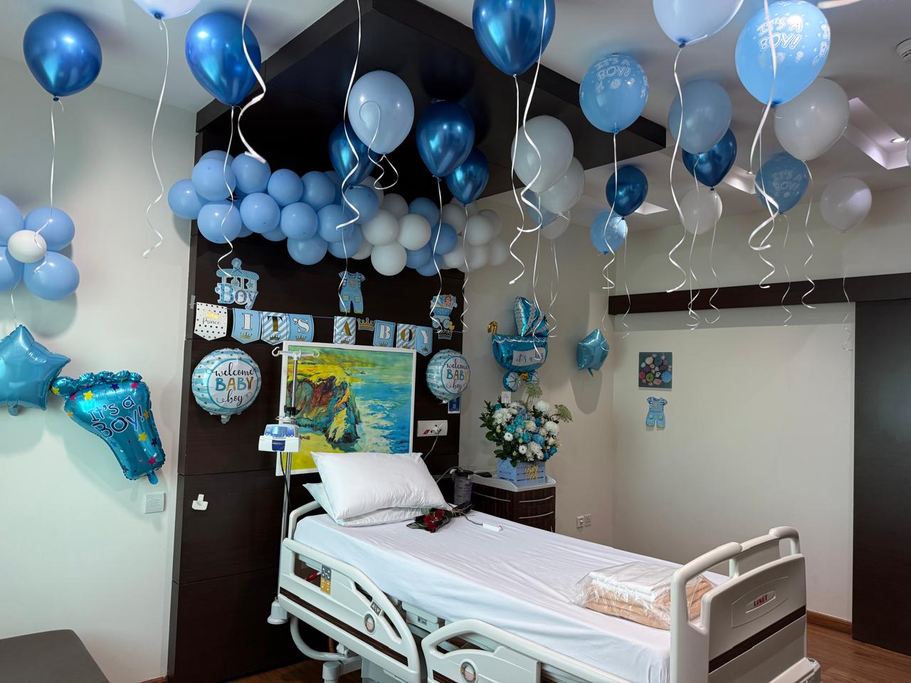 Newborn deco package with blue welcome balloons and hospital room styling